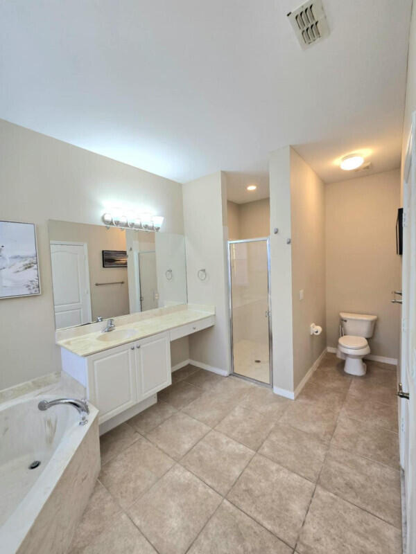 9658 SW Lindale Trace Blvd, Port Saint Lucie, FL 34987 - bathroom with a shower stall, toilet, vanity, a garden tub, and tile patterned flooring