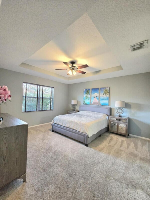 9658 SW Lindale Trace Blvd, Port Saint Lucie, FL 34987 - bedroom with a raised ceiling, carpet flooring, baseboards, and a textured ceiling