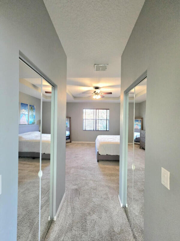 9658 SW Lindale Trace Blvd, Port Saint Lucie, FL 34987 - carpeted bedroom featuring a ceiling fan, baseboards, and a closet