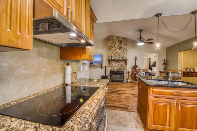 11033 67th Pl N, The Acreage, FL 33412 - kitchen with under cabinet range hood, a sink, brown cabinetry, black electric cooktop, and a ceiling fan