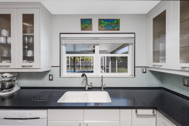 149 SW Grimaldo Ter, Port Saint Lucie, FL 34984 - kitchen featuring dishwasher, a sink, backsplash, and white cabinets