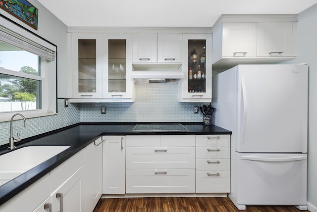 149 SW Grimaldo Ter, Port Saint Lucie, FL 34984 - kitchen with freestanding refrigerator, custom range hood, black electric stovetop, and decorative backsplash