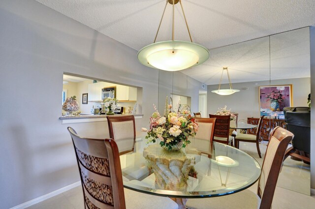 15355 Lakes Of Delray Blvd Unit 211, Delray Beach, FL 33484 - dining space featuring baseboards and a textured ceiling