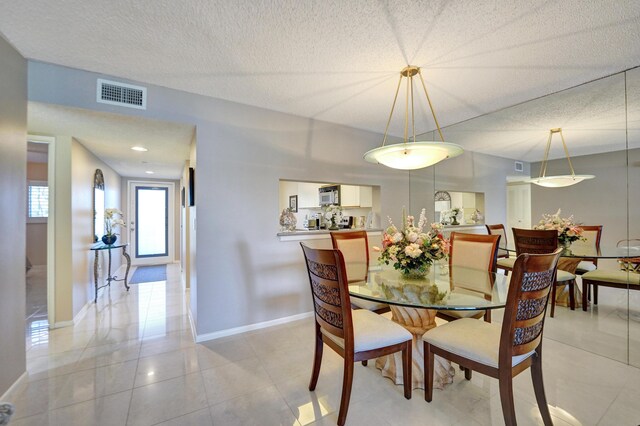 15355 Lakes Of Delray Blvd Unit 211, Delray Beach, FL 33484 - dining room with baseboards, light tile patterned floors, and a textured ceiling