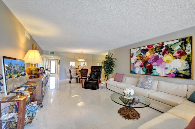 15355 Lakes Of Delray Blvd Unit 211, Delray Beach, FL 33484 - living room featuring a textured ceiling and light tile patterned flooring
