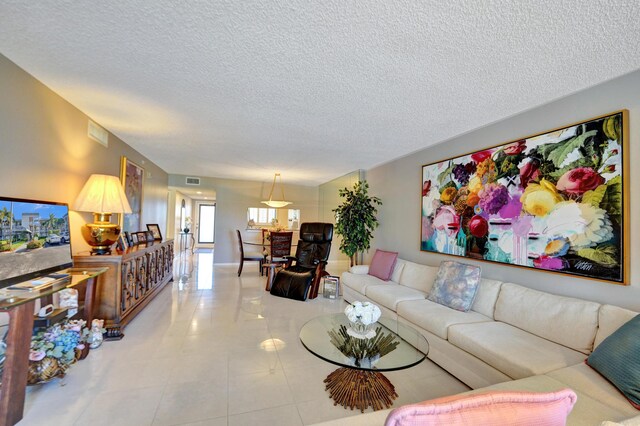 15355 Lakes Of Delray Blvd Unit 211, Delray Beach, FL 33484 - tiled living room featuring a textured ceiling