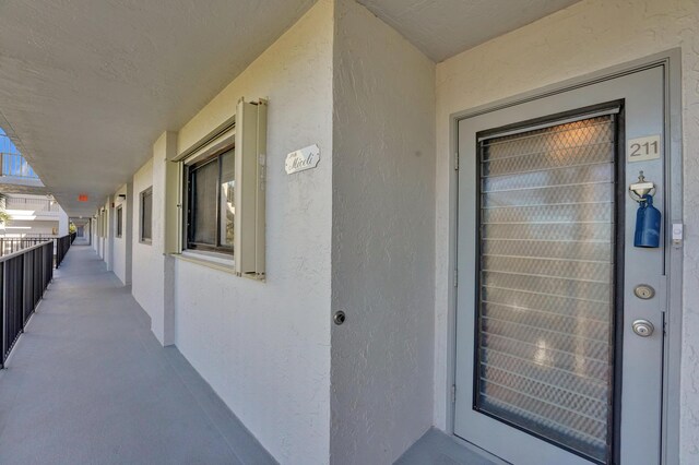 15355 Lakes Of Delray Blvd Unit 211, Delray Beach, FL 33484 - doorway to property with stucco siding