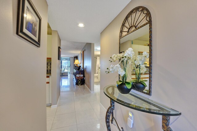 15355 Lakes Of Delray Blvd Unit 211, Delray Beach, FL 33484 - corridor with baseboards and light tile patterned flooring