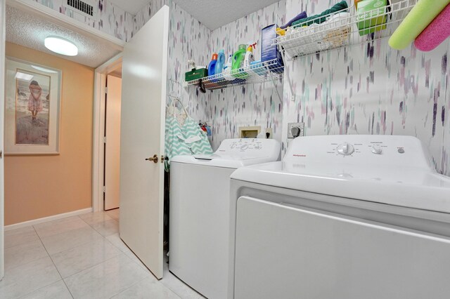 15355 Lakes Of Delray Blvd Unit 211, Delray Beach, FL 33484 - washroom featuring wallpapered walls, washer and clothes dryer, baseboards, a textured ceiling, and tile patterned flooring