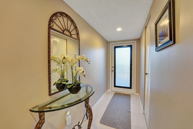 15355 Lakes Of Delray Blvd Unit 211, Delray Beach, FL 33484 - doorway featuring a textured ceiling, light tile patterned floors, baseboards, and recessed lighting