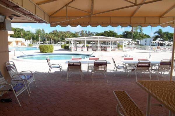15355 Lakes Of Delray Blvd Unit 211, Delray Beach, FL 33484 - community pool featuring a patio