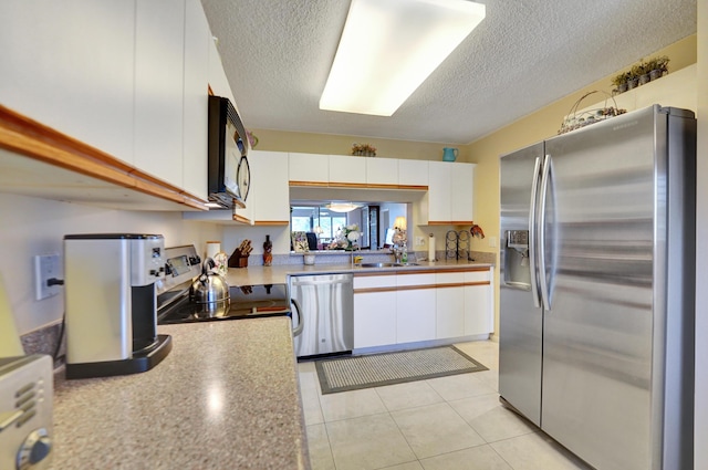 15355 Lakes Of Delray Blvd Unit 211, Delray Beach, FL 33484 - kitchen featuring stainless steel appliances, a textured ceiling, white cabinetry, a sink, and light countertops