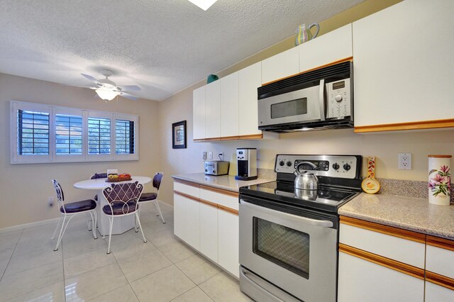 15355 Lakes Of Delray Blvd Unit 211, Delray Beach, FL 33484 - kitchen featuring stainless steel appliances, a textured ceiling, light countertops, light tile patterned floors, and ceiling fan