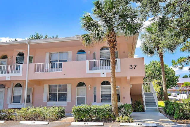 18081 SE Country Club Dr Unit 370, Tequesta, FL 33469 - view of property featuring stairway and uncovered parking