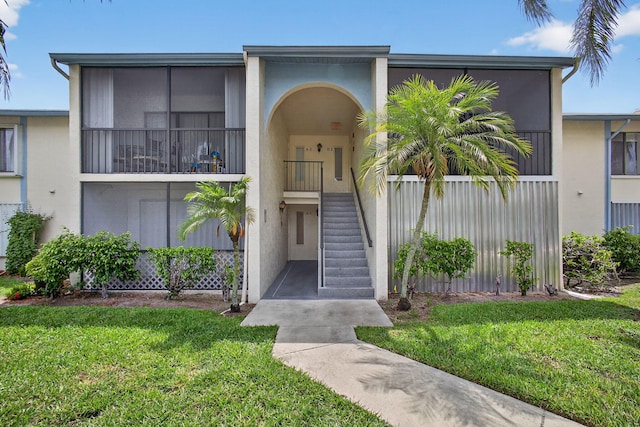 1104 Green Pine Blvd Unit D2, West Palm Beach, FL 33409 - view of front of property with stairway, a front yard, and stucco siding