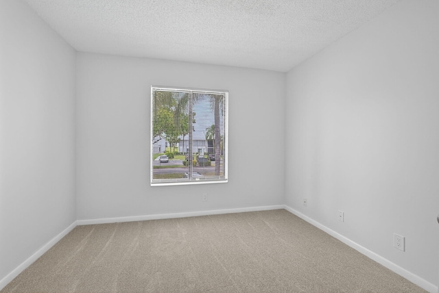 1104 Green Pine Blvd Unit D2, West Palm Beach, FL 33409 - carpeted spare room featuring a textured ceiling and baseboards