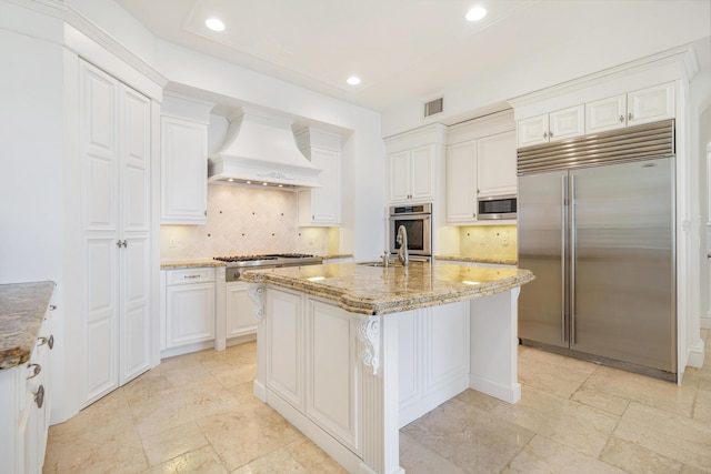 3309 S Flagler Dr, West Palm Beach, FL 33405 - kitchen with appliances with stainless steel finishes, custom range hood, light stone counters, decorative backsplash, and recessed lighting