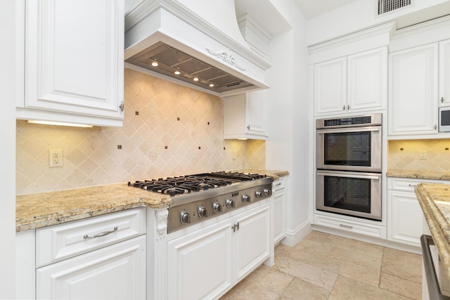 3309 S Flagler Dr, West Palm Beach, FL 33405 - kitchen featuring stainless steel appliances, premium range hood, backsplash, white cabinets, and light stone counters