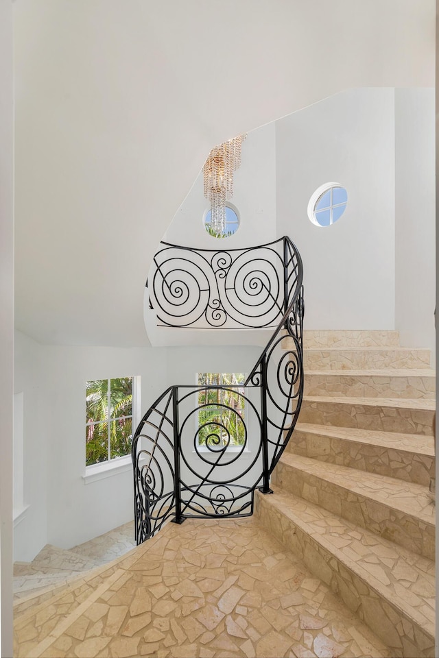3309 S Flagler Dr, West Palm Beach, FL 33405 - staircase featuring a chandelier and stone finish floors