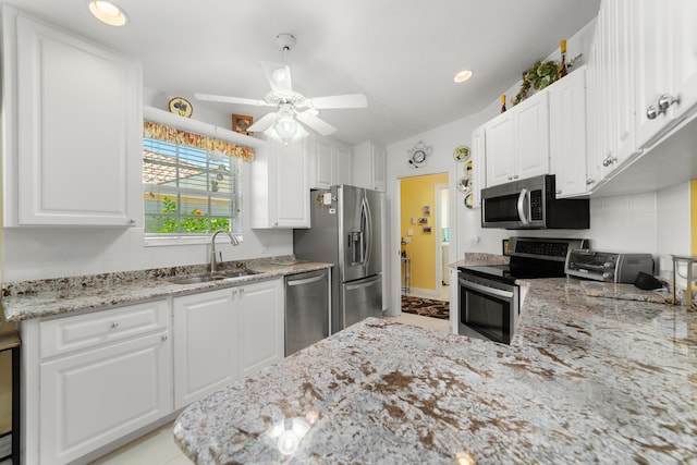 1056 SW Balmoral Trce, Stuart, FL 34997 - kitchen featuring appliances with stainless steel finishes, a sink, ceiling fan, white cabinets, and light stone countertops