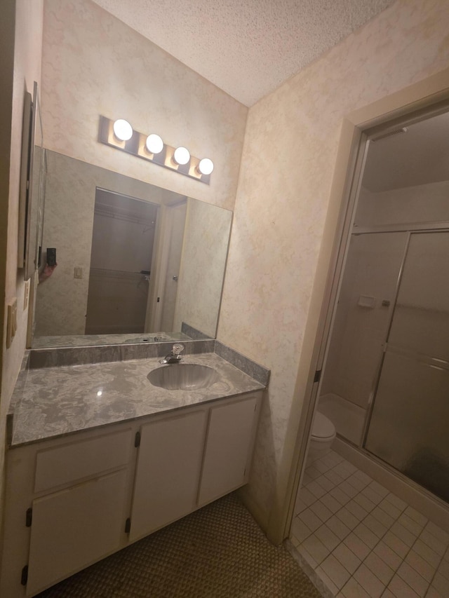 7690 Tahiti Ln Unit 202, Lake Worth, FL 33467 - bathroom featuring a textured ceiling, a shower stall, vanity, toilet, and tile patterned floors