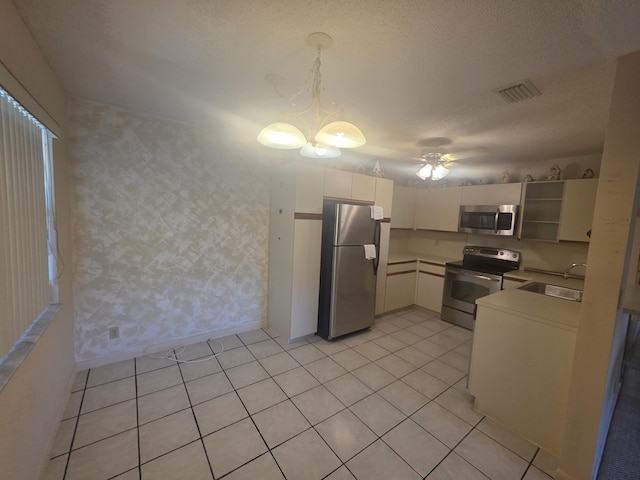7690 Tahiti Ln Unit 202, Lake Worth, FL 33467 - kitchen featuring appliances with stainless steel finishes, a sink, open shelves, light tile patterned floors, and pendant lighting