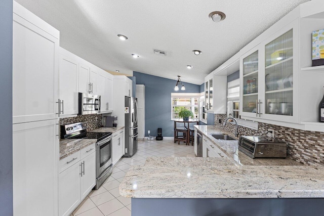 5350 Casa Real Dr, Delray Beach, FL 33484 - kitchen with appliances with stainless steel finishes, a sink, decorative backsplash, vaulted ceiling, and light tile patterned flooring