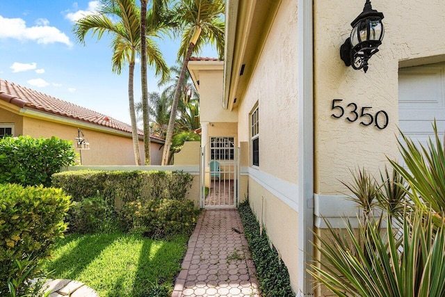 5350 Casa Real Dr, Delray Beach, FL 33484 - view of property exterior featuring stucco siding and a gate