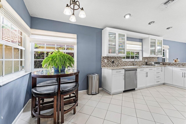 5350 Casa Real Dr, Delray Beach, FL 33484 - kitchen featuring dishwasher, white cabinetry, glass insert cabinets, decorative backsplash, and baseboards