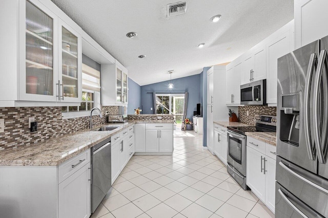 5350 Casa Real Dr, Delray Beach, FL 33484 - kitchen with stainless steel appliances, a peninsula, a sink, lofted ceiling, and backsplash