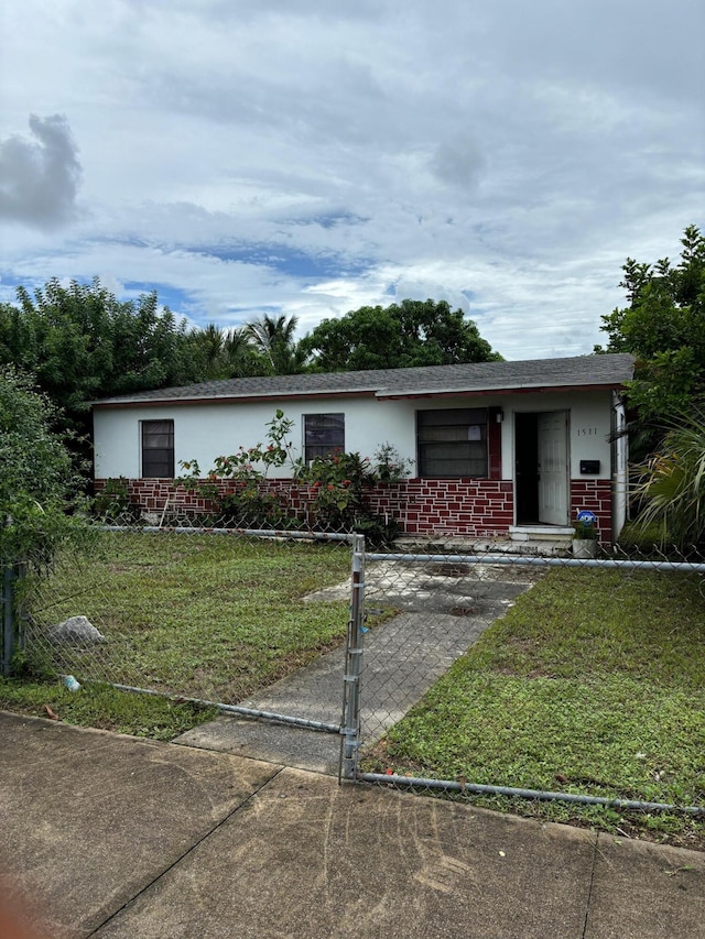 1511 W 32nd St, Riviera Beach, FL 33404 - single story home featuring a front lawn, brick siding, a gate, and stucco siding