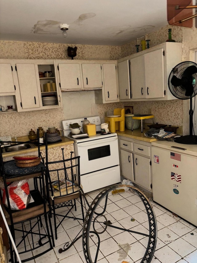 1511 W 32nd St, Riviera Beach, FL 33404 - kitchen with white electric stove, light countertops, light tile patterned floors, and open shelves