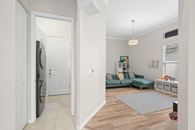 225 NW Magnolia Lakes Blvd, Port Saint Lucie, FL 34986 - corridor with estacked washer and dryer, ornamental molding, baseboards, and light wood-style floors