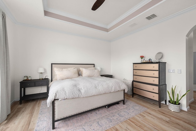 225 NW Magnolia Lakes Blvd, Port Saint Lucie, FL 34986 - bedroom with arched walkways, a raised ceiling, light wood-style floors, crown molding, and baseboards