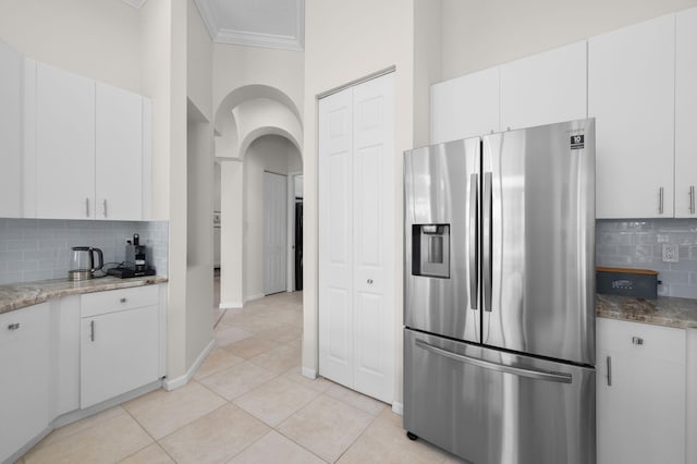 225 NW Magnolia Lakes Blvd, Port Saint Lucie, FL 34986 - kitchen featuring stainless steel fridge, arched walkways, decorative backsplash, light stone counters, and crown molding