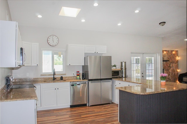 2182 SE Bersell Rd, Port Saint Lucie, FL 34952 - kitchen featuring a sink, appliances with stainless steel finishes, light stone counters, wood finished floors, and a skylight