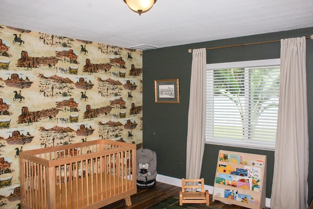 2182 SE Bersell Rd, Port Saint Lucie, FL 34952 - bedroom featuring a crib, wood finished floors, multiple windows, and baseboards