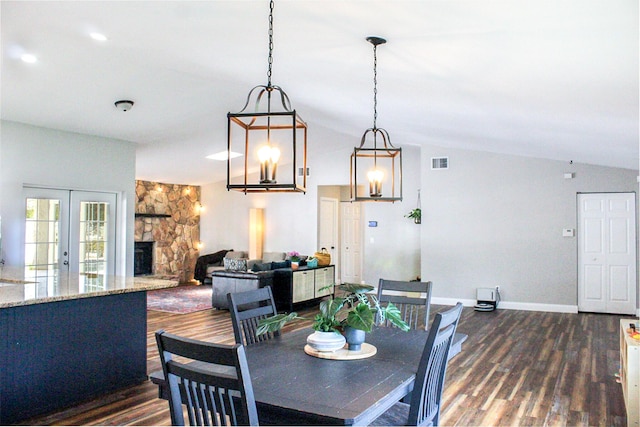 2182 SE Bersell Rd, Port Saint Lucie, FL 34952 - dining area with dark wood finished floors, lofted ceiling, a stone fireplace, and baseboards