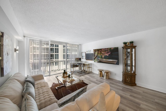 3570 S Ocean Blvd Unit 506, South Palm Beach, FL 33480 - living area with a textured ceiling, wood finished floors, floor to ceiling windows, and baseboards
