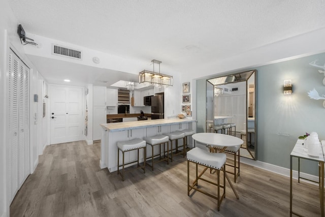3570 S Ocean Blvd Unit 506, South Palm Beach, FL 33480 - kitchen with freestanding refrigerator, a peninsula, and light wood-type flooring