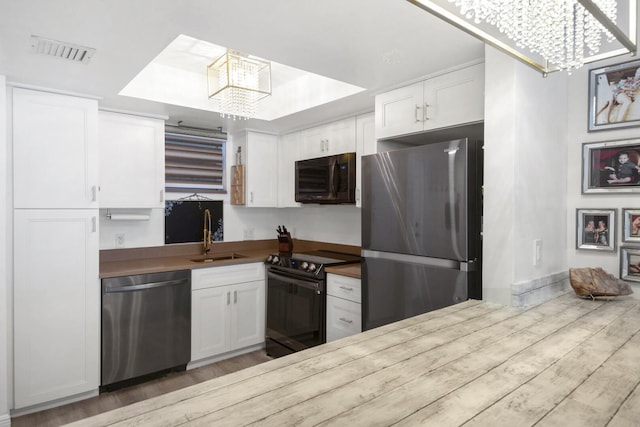 3570 S Ocean Blvd Unit 506, South Palm Beach, FL 33480 - kitchen featuring black appliances, a chandelier, a sink, and white cabinetry