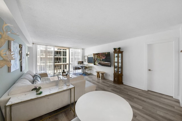 3570 S Ocean Blvd Unit 506, South Palm Beach, FL 33480 - living room featuring wood finished floors, a textured ceiling, and a wall of windows