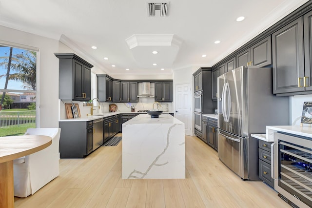 9800 Stover Way, Wellington, FL 33414 - kitchen featuring wine cooler, wall chimney exhaust hood, a kitchen island, stainless steel appliances, and light stone counters