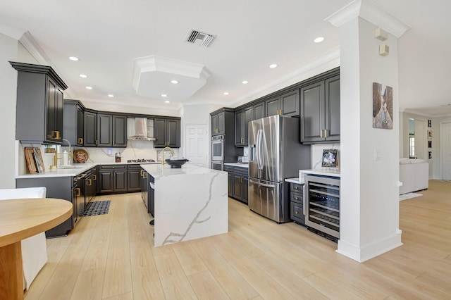 9800 Stover Way, Wellington, FL 33414 - kitchen featuring appliances with stainless steel finishes, beverage cooler, wall chimney exhaust hood, a center island with sink, and crown molding