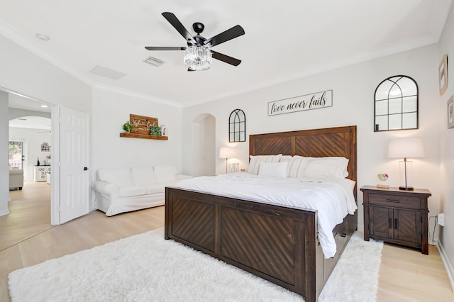 9800 Stover Way, Wellington, FL 33414 - bedroom featuring arched walkways, light wood-style floors, crown molding, ceiling fan, and baseboards