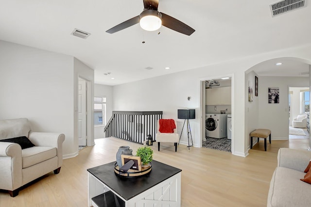 9800 Stover Way, Wellington, FL 33414 - living room with arched walkways, independent washer and dryer, light wood finished floors, a ceiling fan, and baseboards
