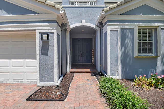 9800 Stover Way, Wellington, FL 33414 - view of exterior entry featuring stucco siding and a garage