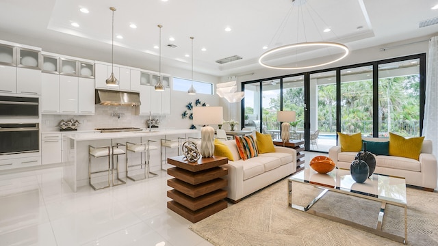 13206 Faberge Pl, Palm Beach Gardens, FL 33418 - living area featuring a raised ceiling, healthy amount of natural light, and recessed lighting