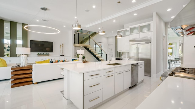 13206 Faberge Pl, Palm Beach Gardens, FL 33418 - kitchen with light tile patterned floors, a sink, white cabinetry, a spacious island, and stainless steel appliances