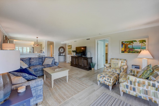 2641 NE Ocean Blvd Unit 106, Stuart, FL 34996 - living room with crown molding, light wood finished floors, and a chandelier